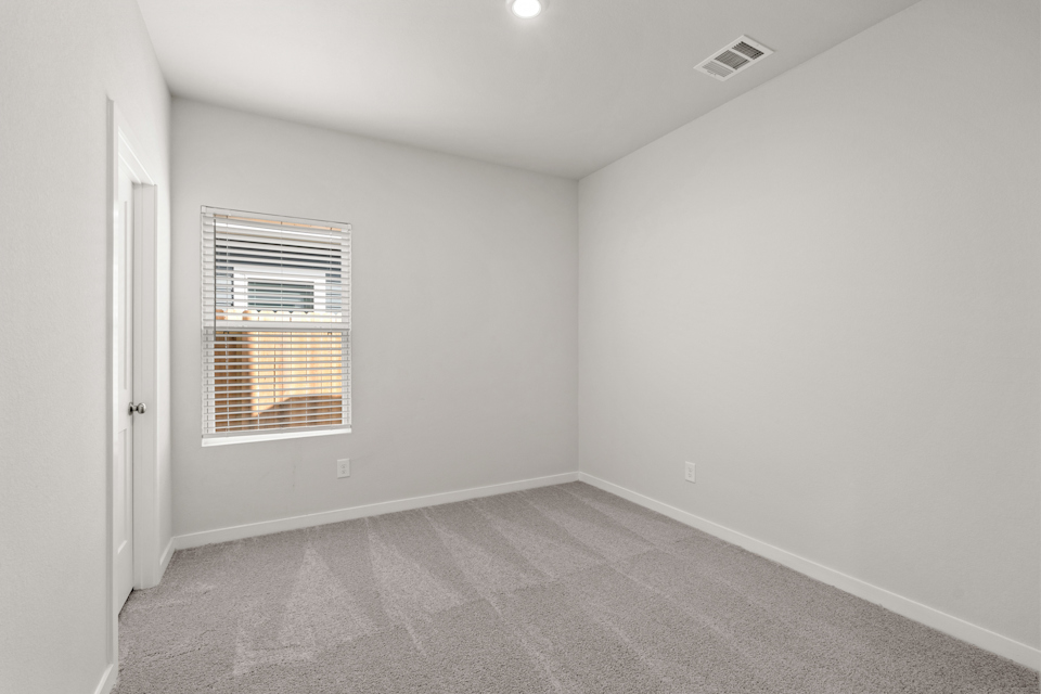 A room with a window and a carpet.