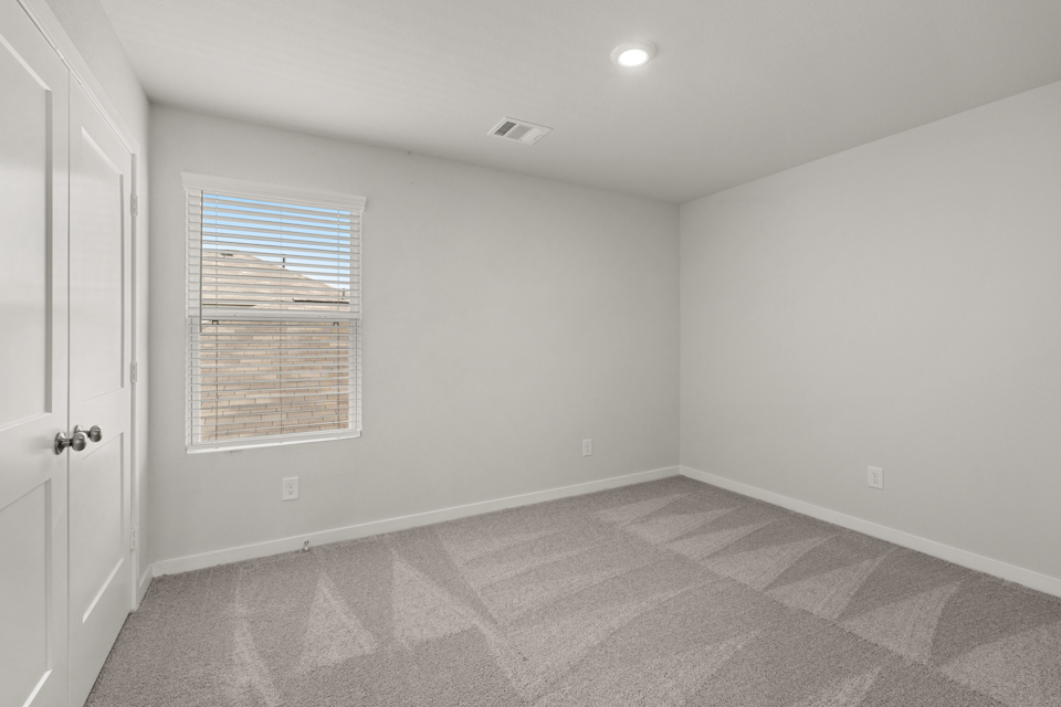 A room with a window and a rug.