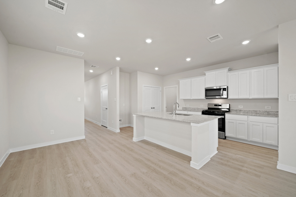 A kitchen with white cabinets.