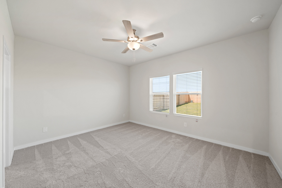 A room with a ceiling fan and a window.