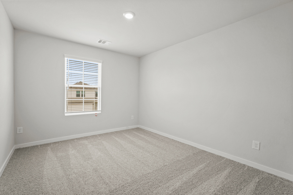 A room with a window and a carpet.