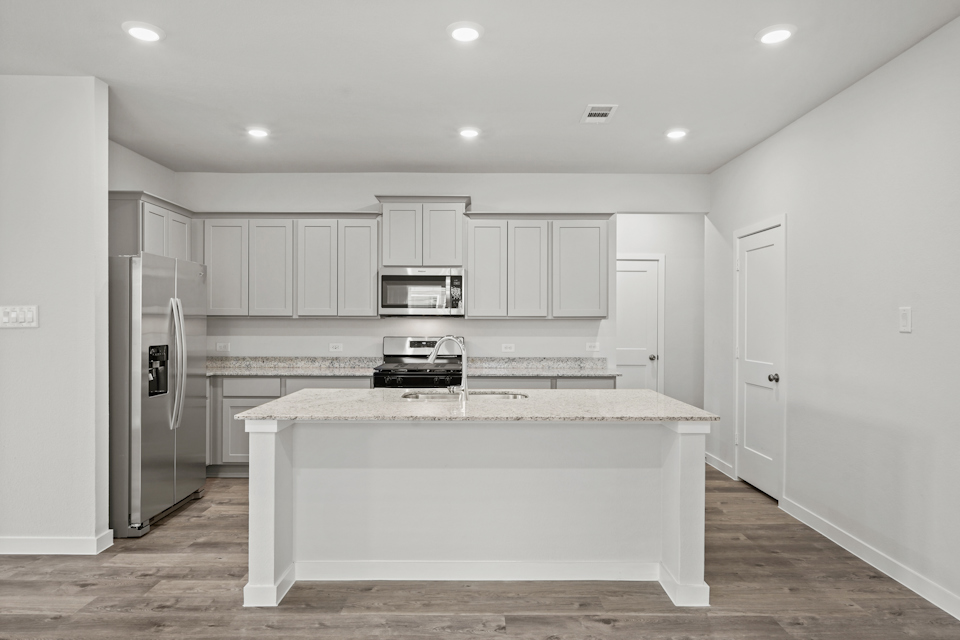 A kitchen with white cabinets.