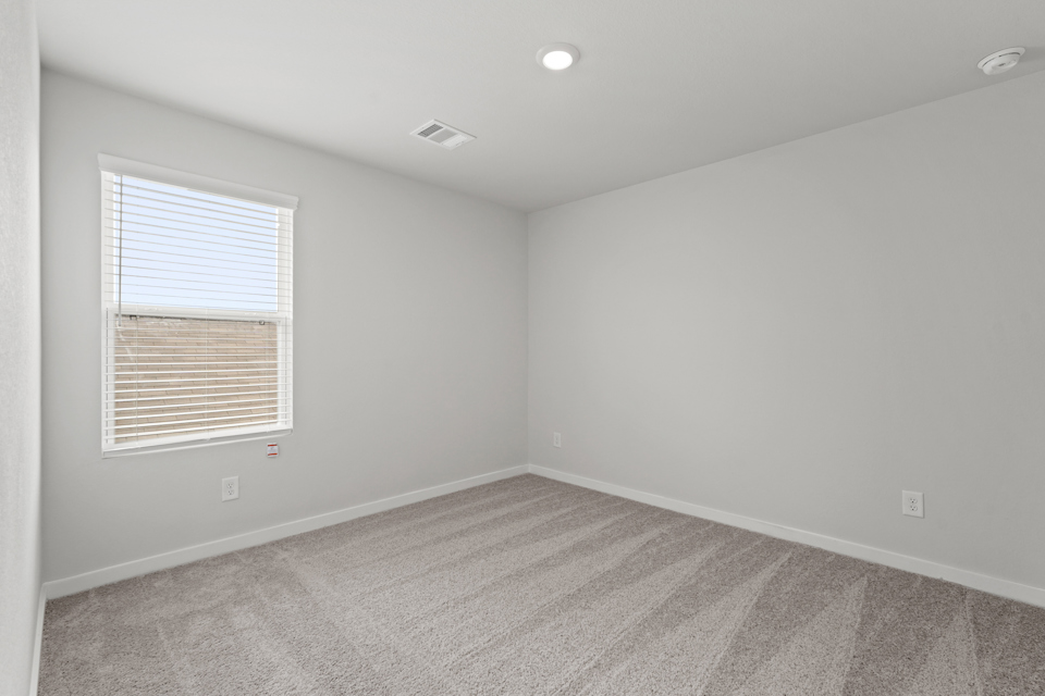 A room with a carpet and a window.