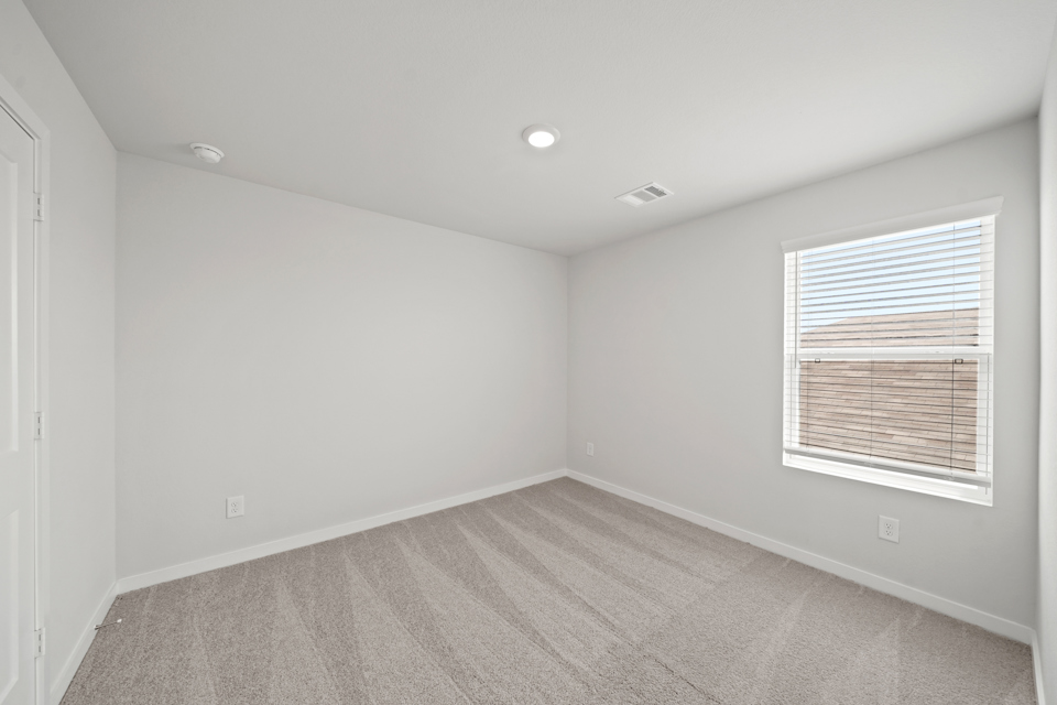 A room with a window and a rug.