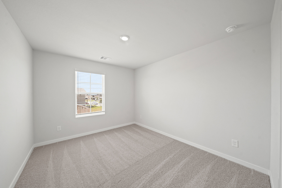 A room with a window and a carpet.