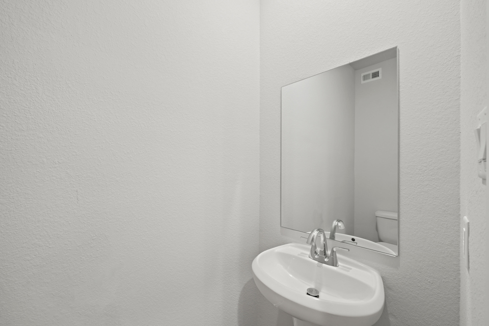 A bathroom with a mirror and sink.