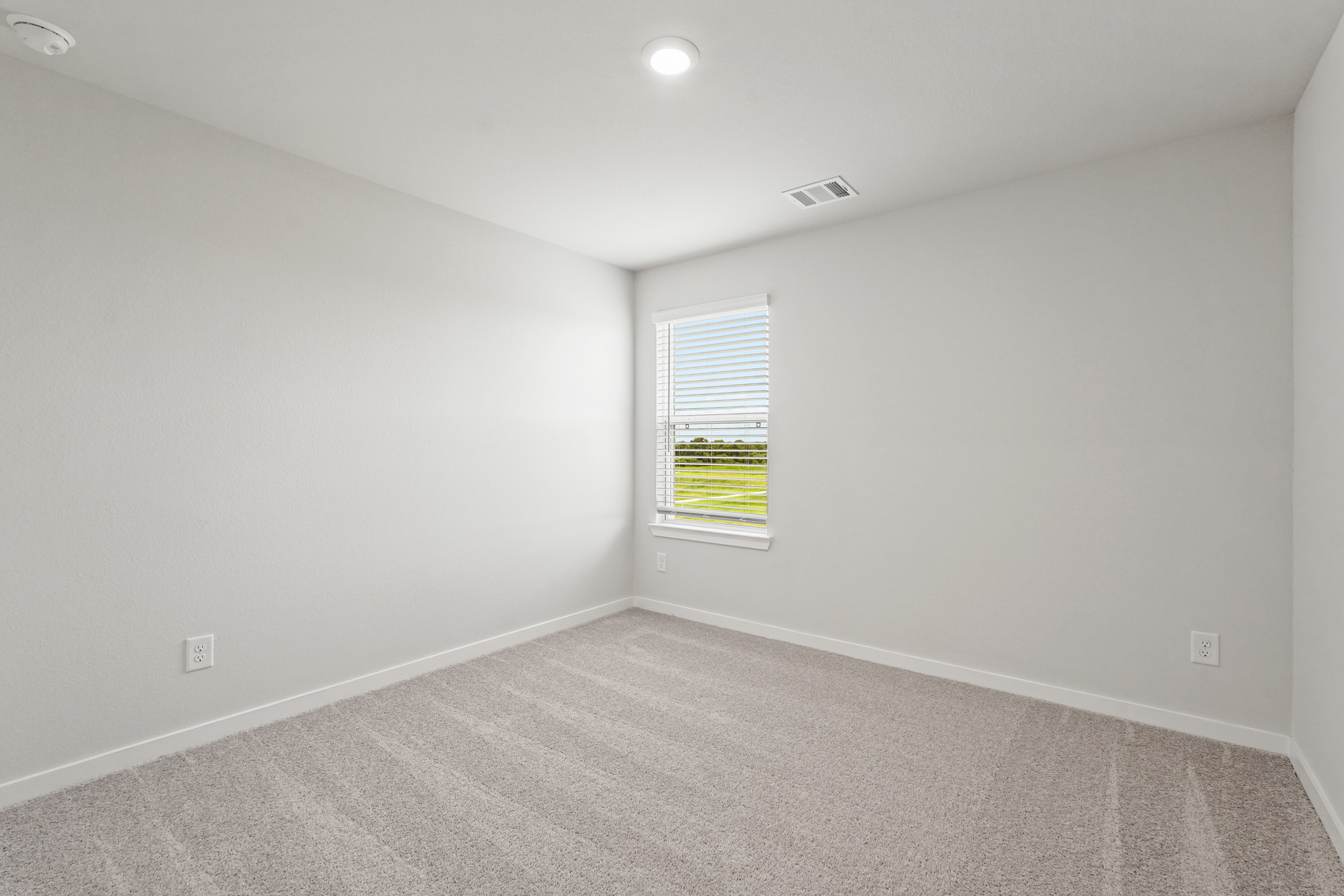 A room with a window and a carpet.