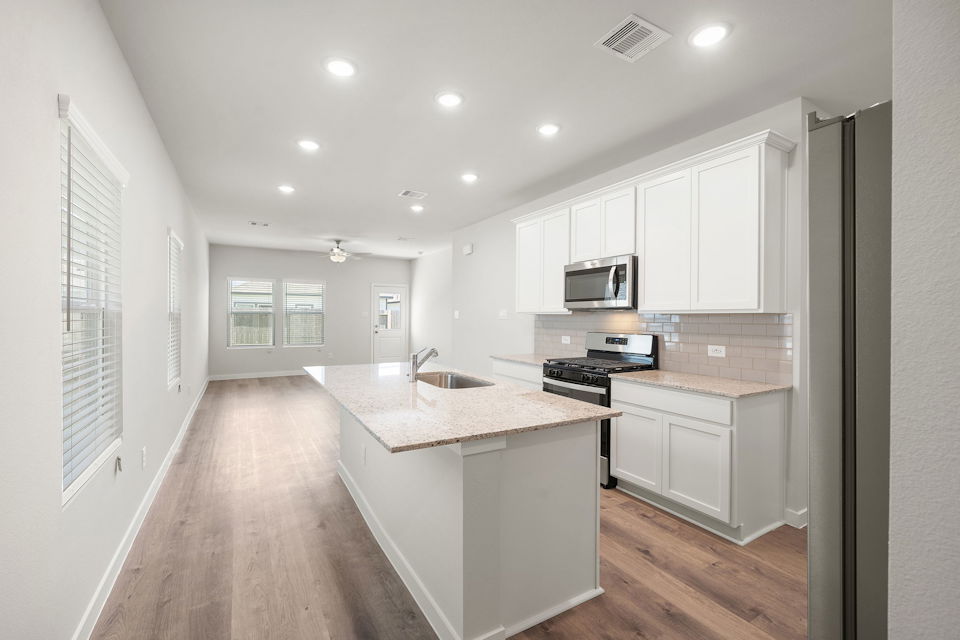 A kitchen with white cabinets.