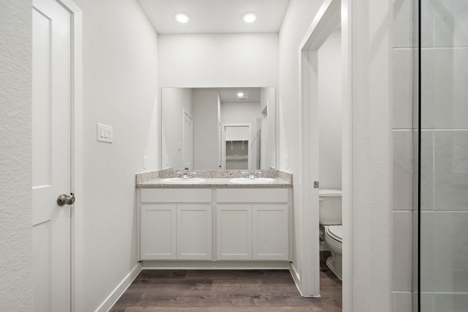 A bathroom with white cabinets.