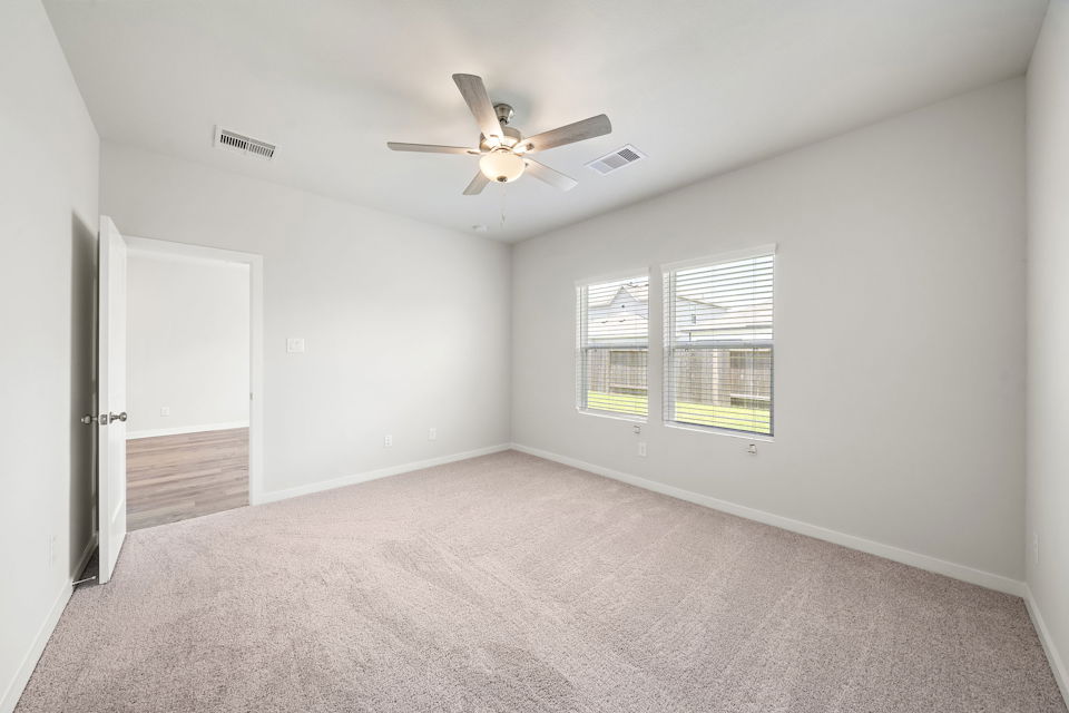 A room with a ceiling fan and a window.