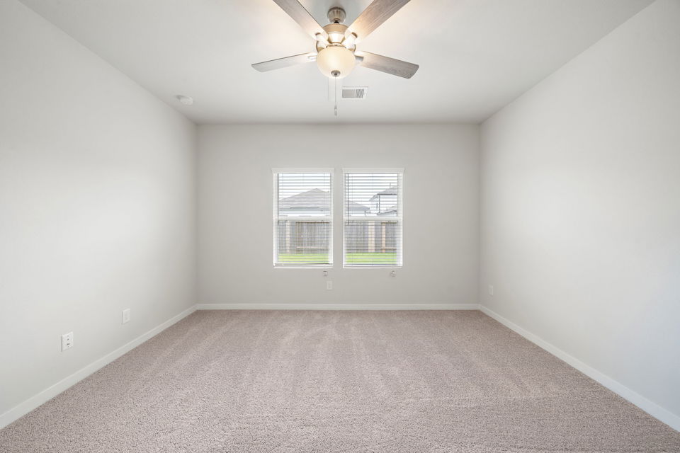 A room with a ceiling fan and a window.