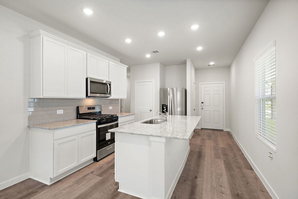 A kitchen with white cabinets.