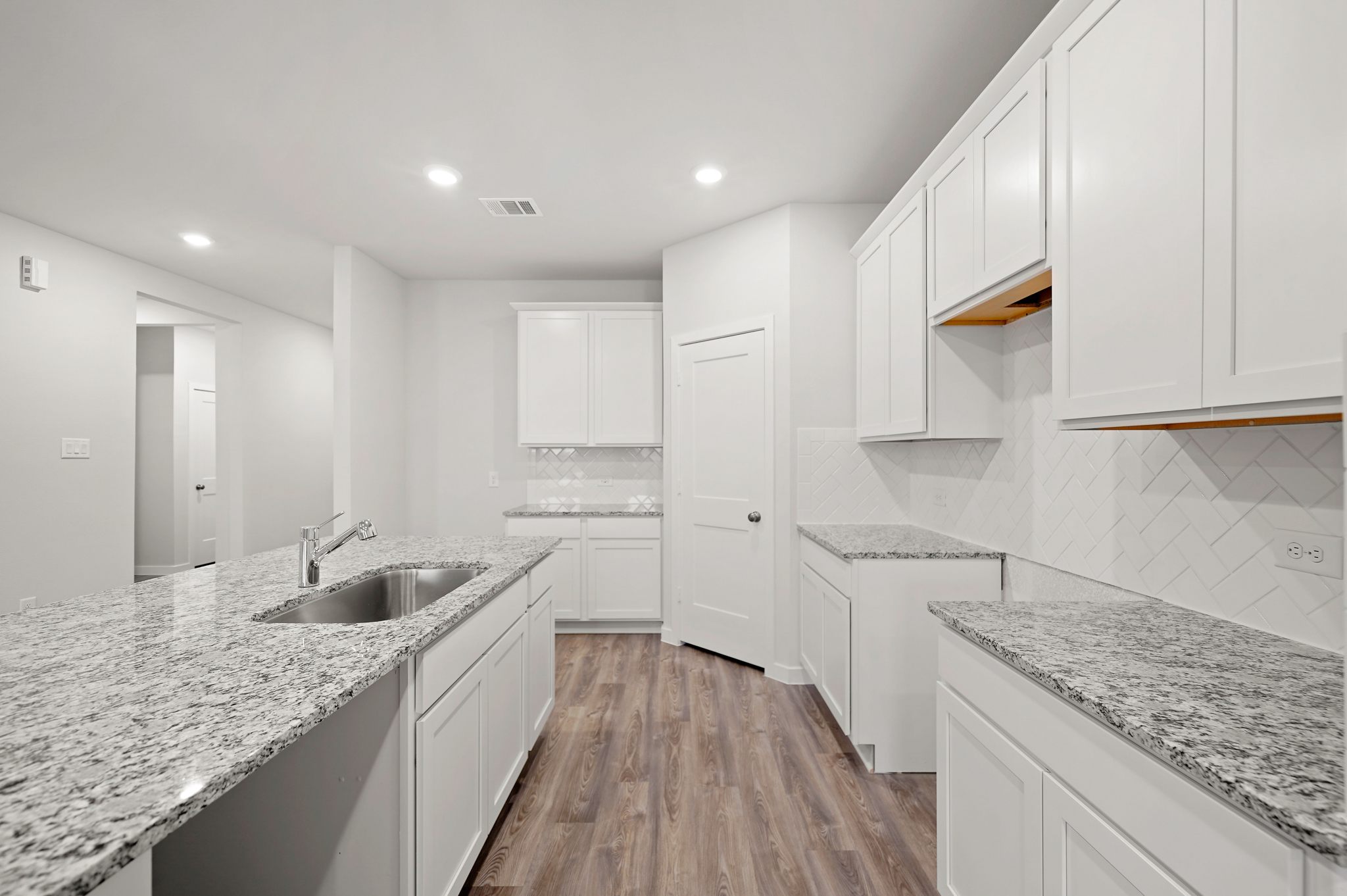 A kitchen with white cabinets.