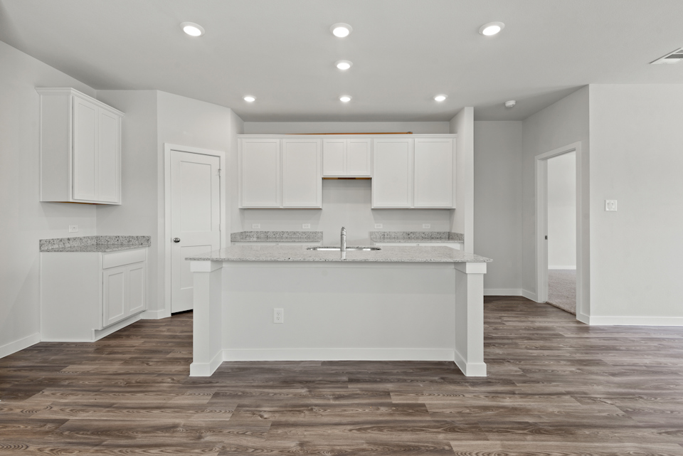 A kitchen with white cabinets.