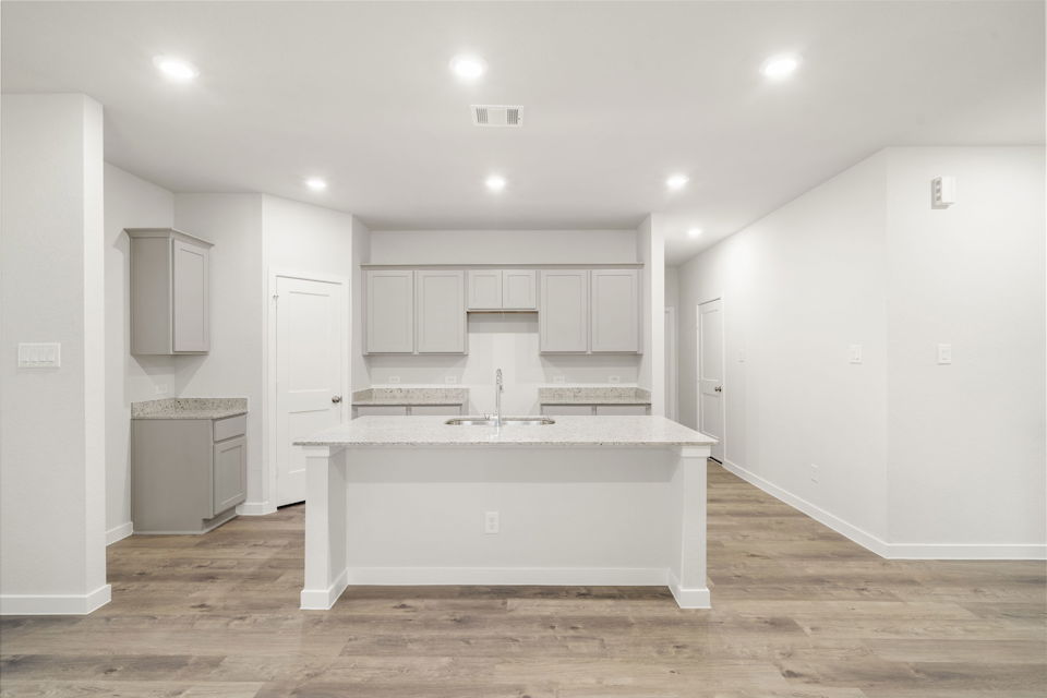 A kitchen with white cabinets.