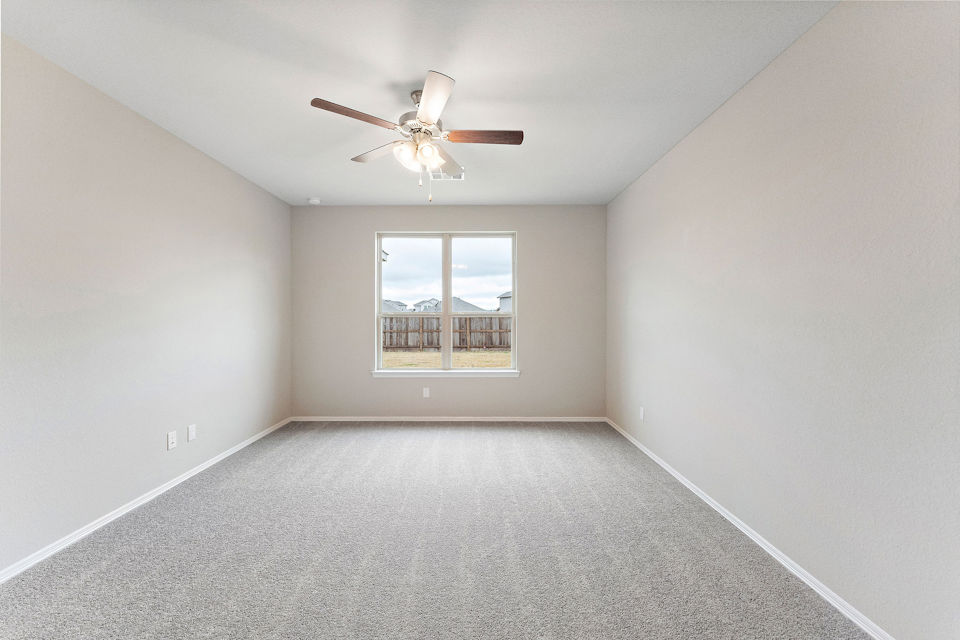 A room with a ceiling fan and a window.