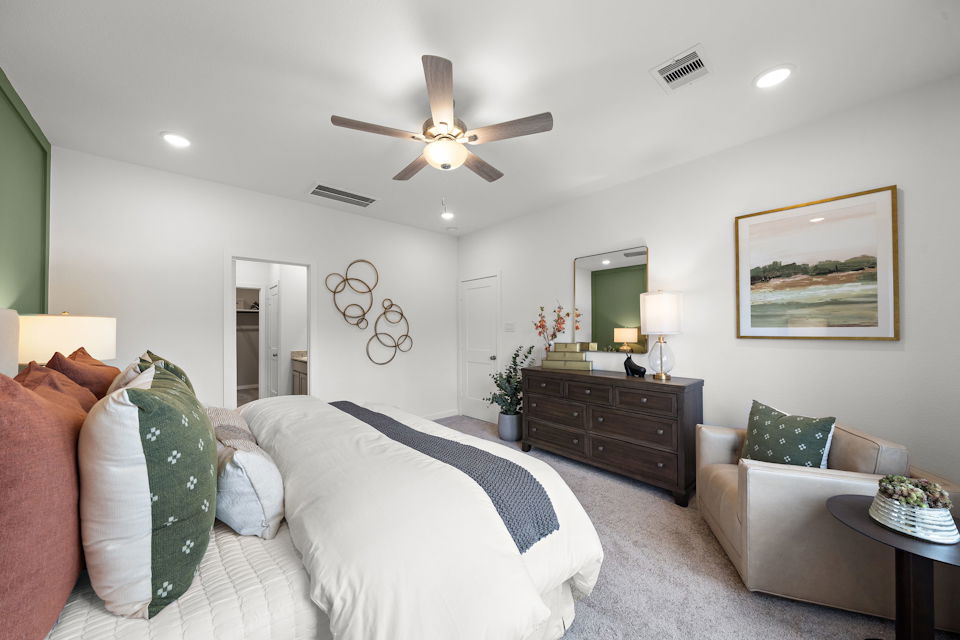 A bedroom with a bed and a fan.