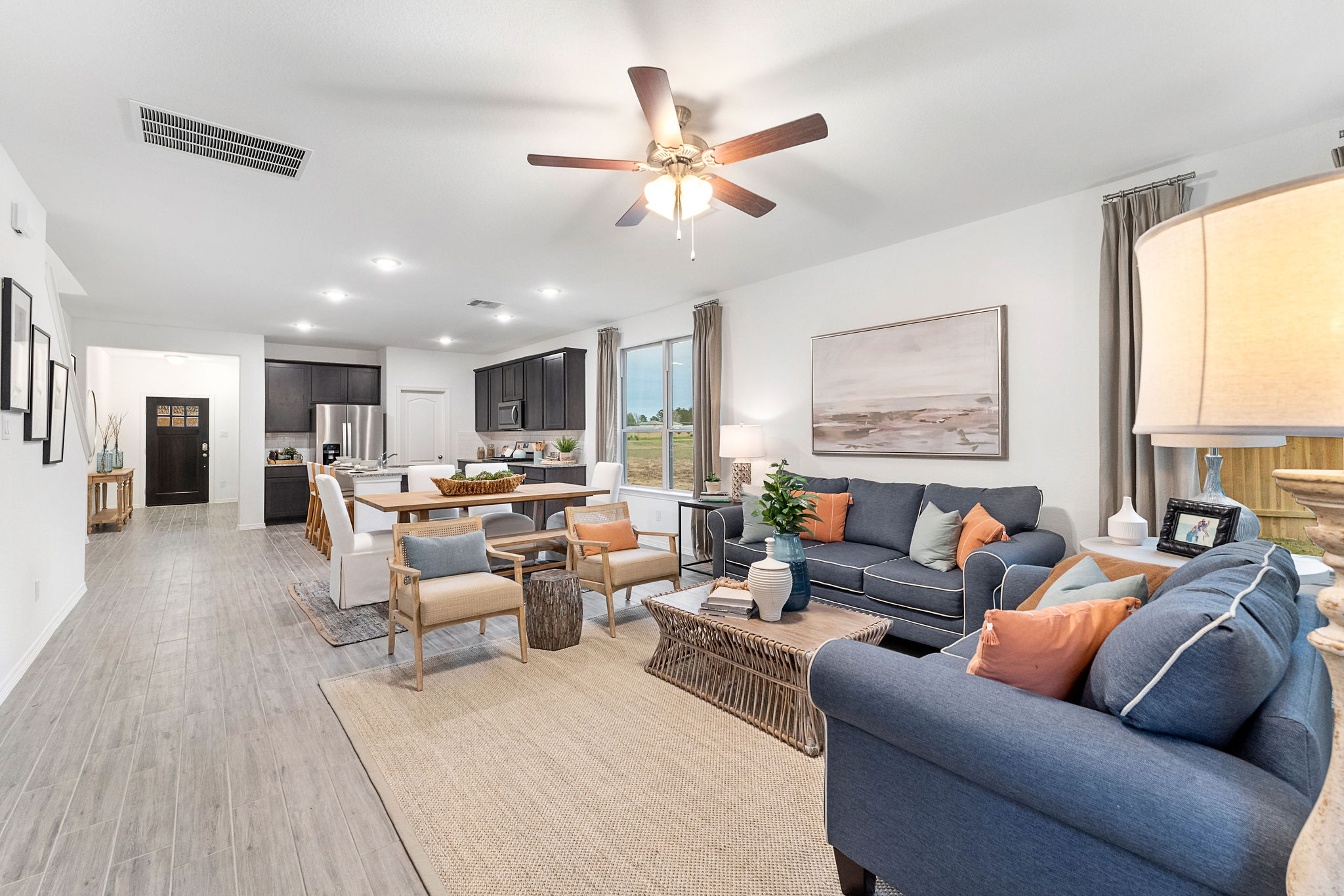 A living room with a large ceiling fan and a wood floor.
