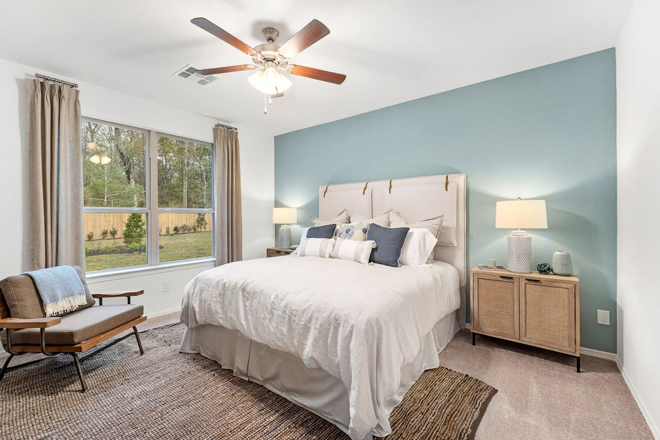 A bedroom with a bed and a fan.