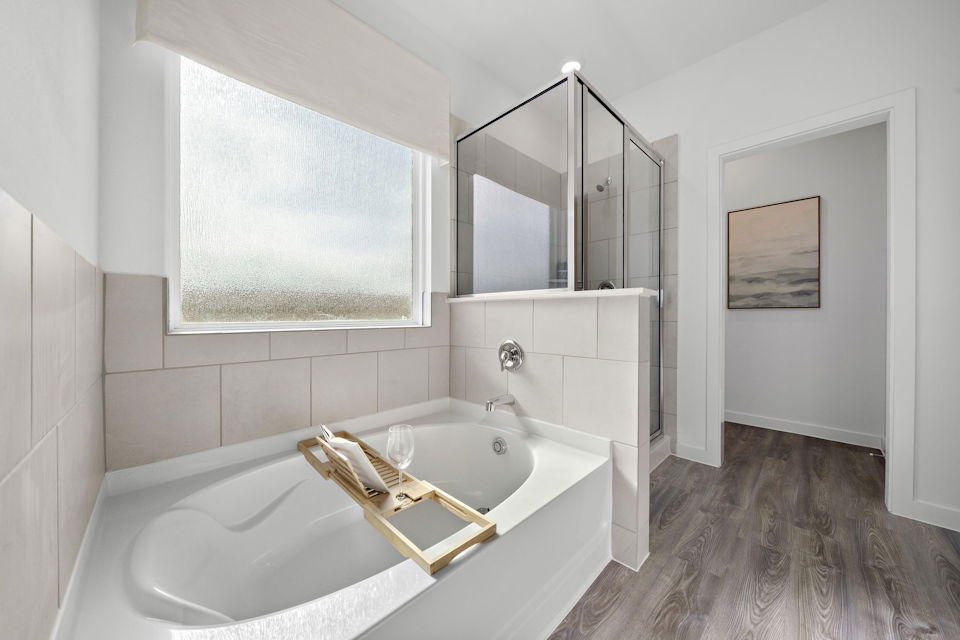 A bathroom with a tub sink and a mirror.