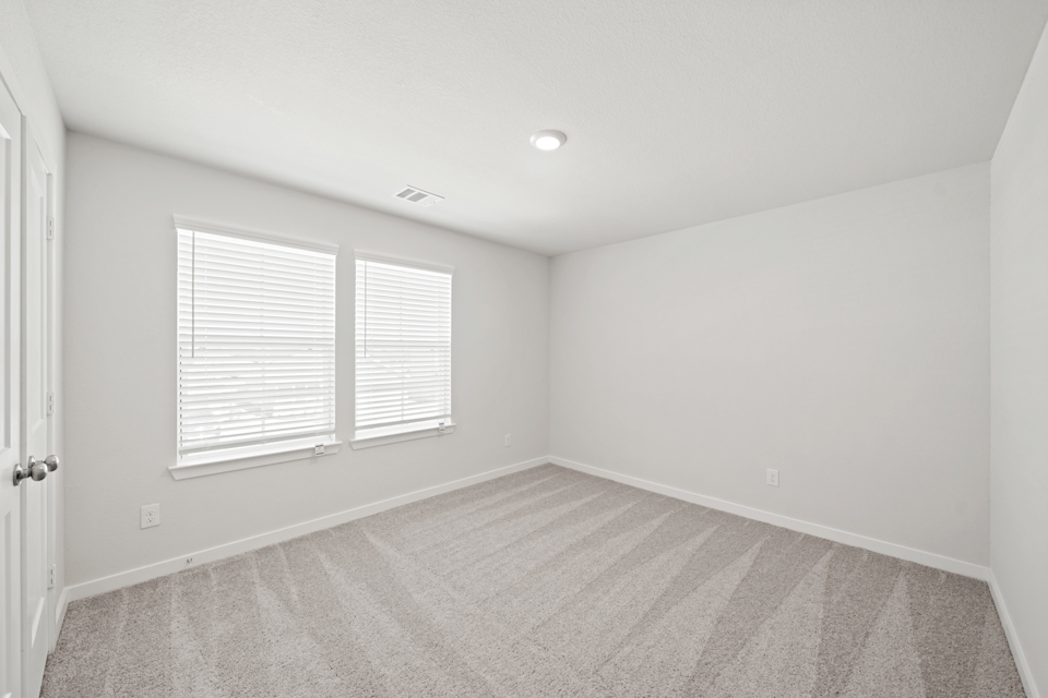 A room with a carpet and a window.