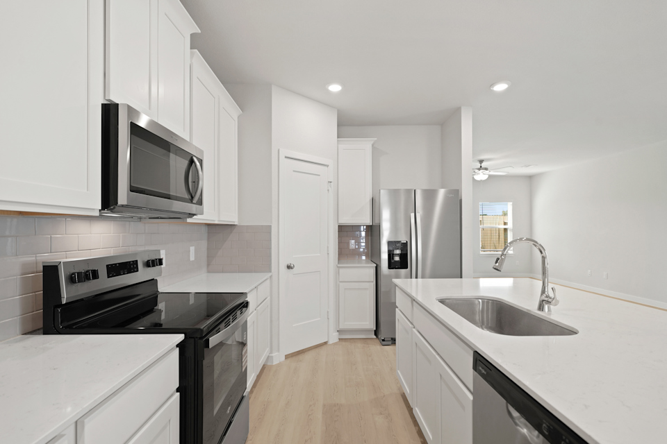 A kitchen with white cabinets.