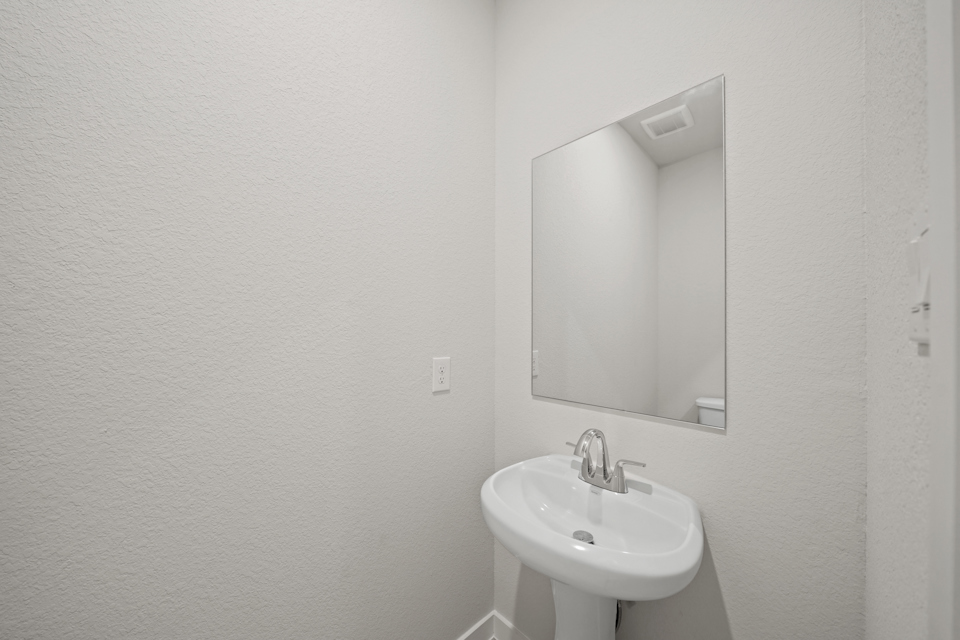 A bathroom with a mirror and sink.