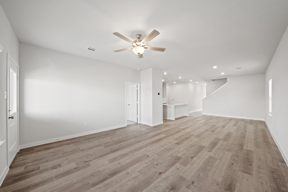 A room with a wood floor and a ceiling fan.