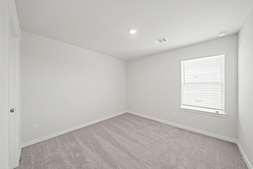 A room with a carpet and a window.