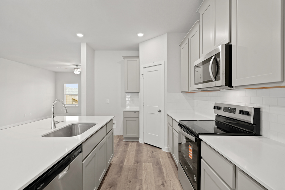 A kitchen with white cabinets.