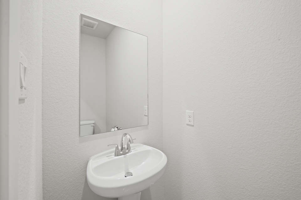 A bathroom with a mirror and sink.