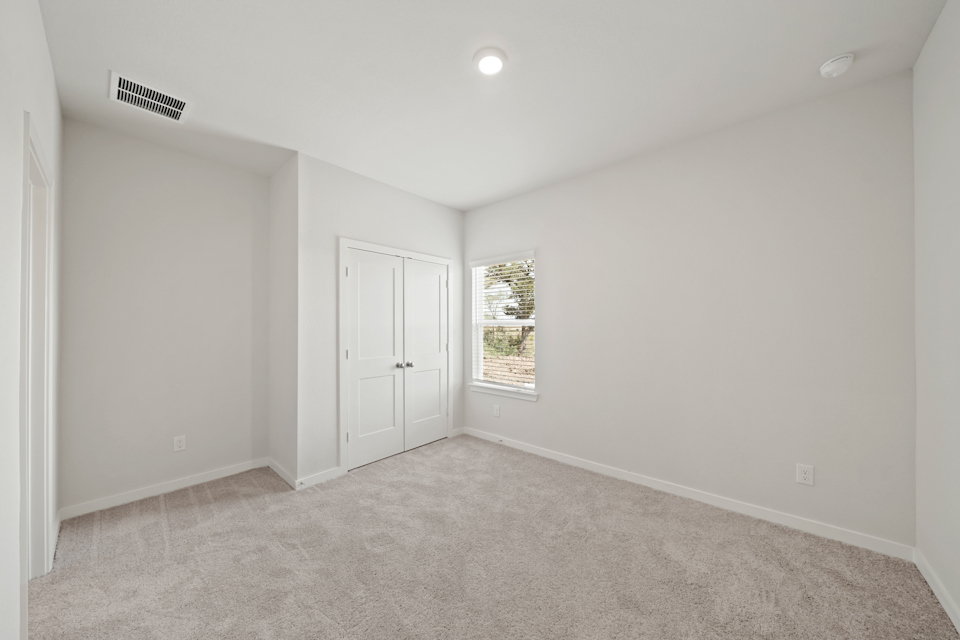 A room with white walls and a window.