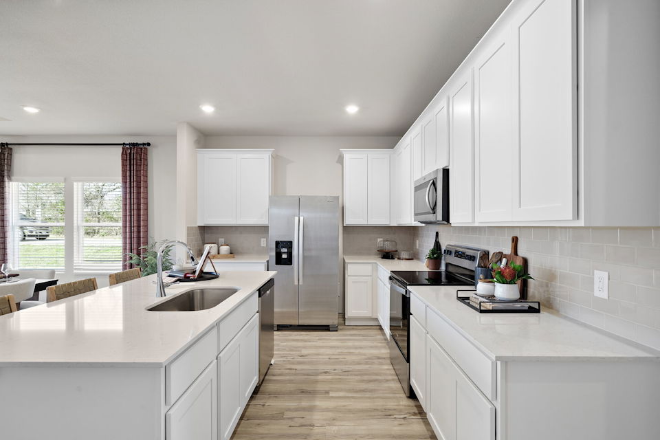 A kitchen with white cabinets.