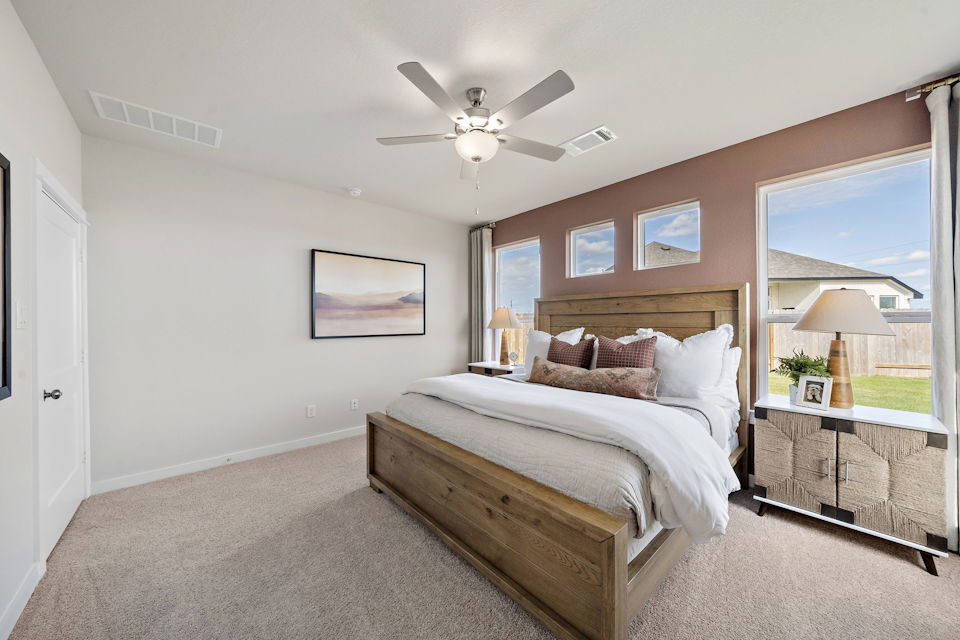 A bedroom with a bed and a fan.