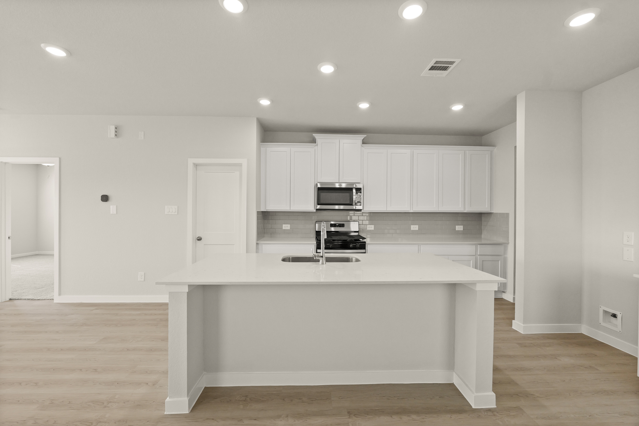 A kitchen with white cabinets.