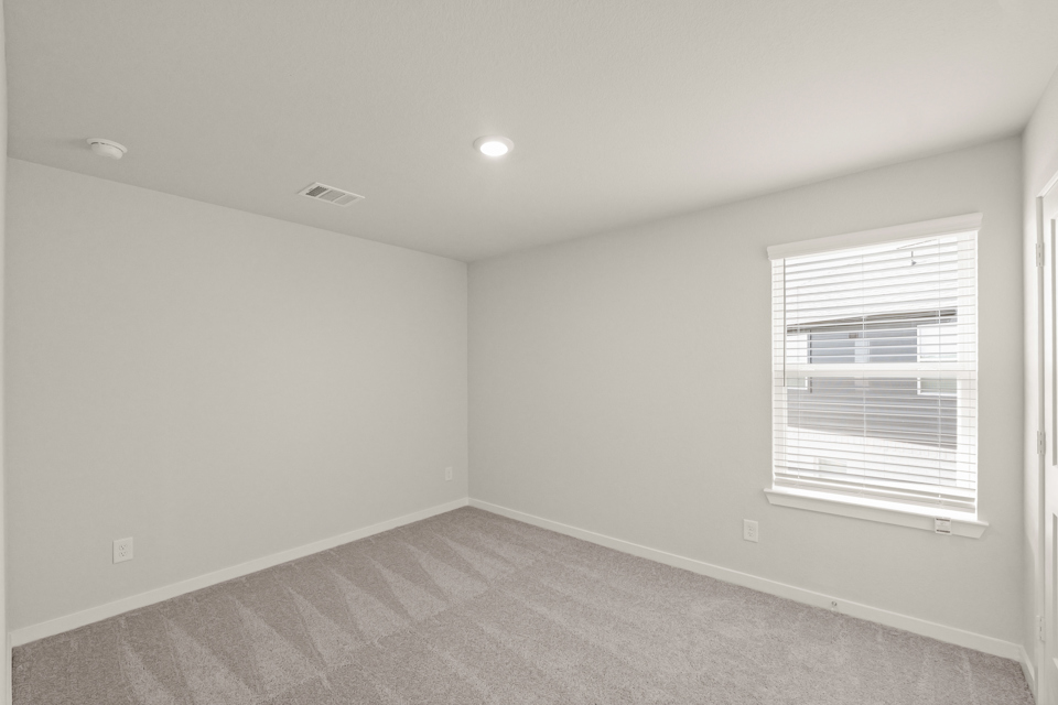 A room with a window and a carpet.