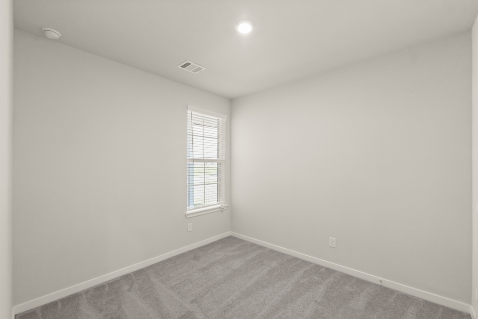 A room with a carpet and a window.