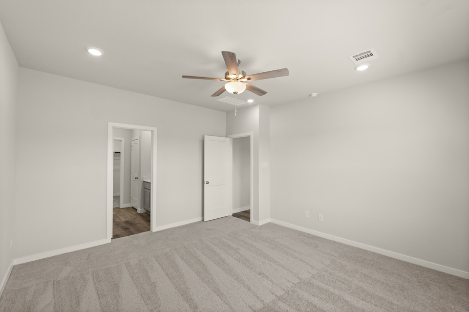 A room with a ceiling fan and a door.