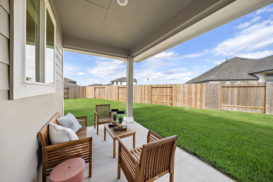 A patio with chairs and a table.