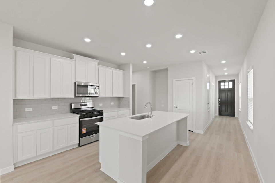 A kitchen with white cabinets.