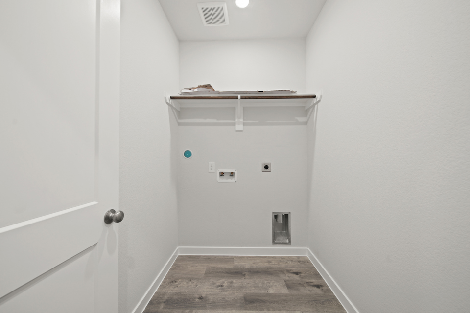 A room with a door and a shelf with a light on it.