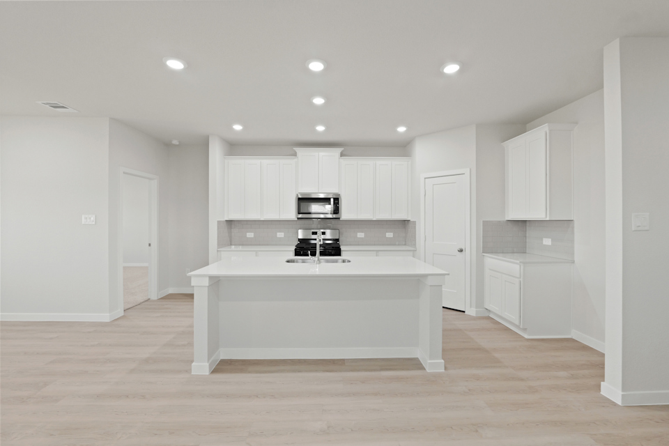 A kitchen with white cabinets.
