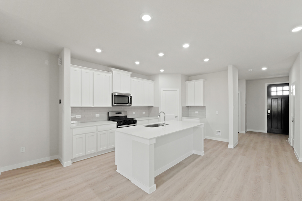 A kitchen with white cabinets.