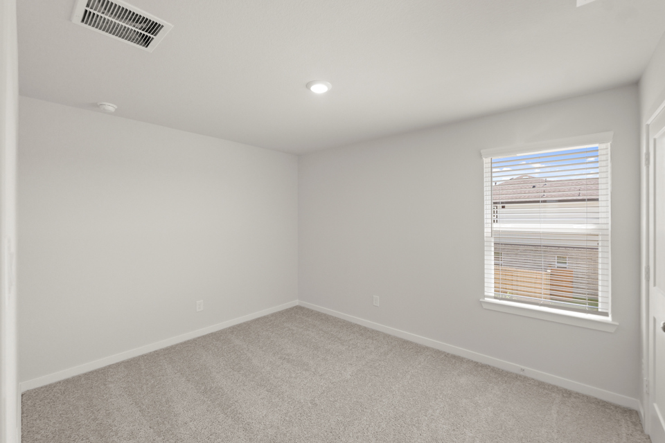 A room with a window and a carpet.