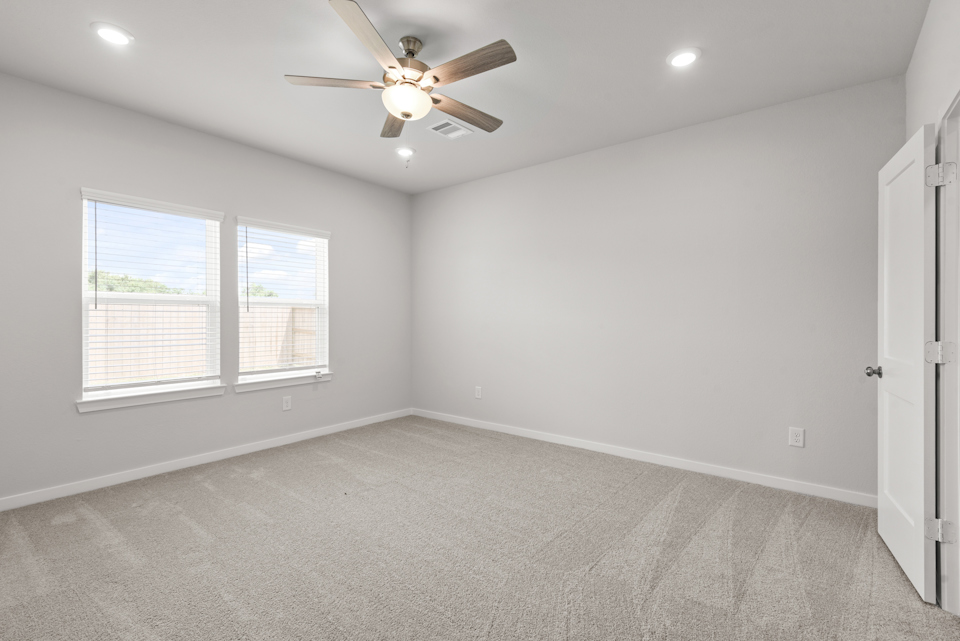 A room with a ceiling fan and a window.