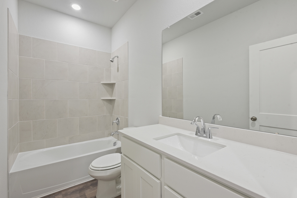 A bathroom with a tub sink and toilet.