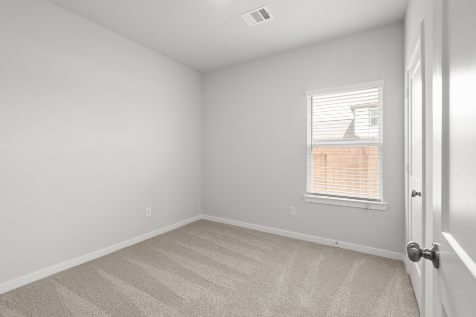 A room with a window and a carpet.