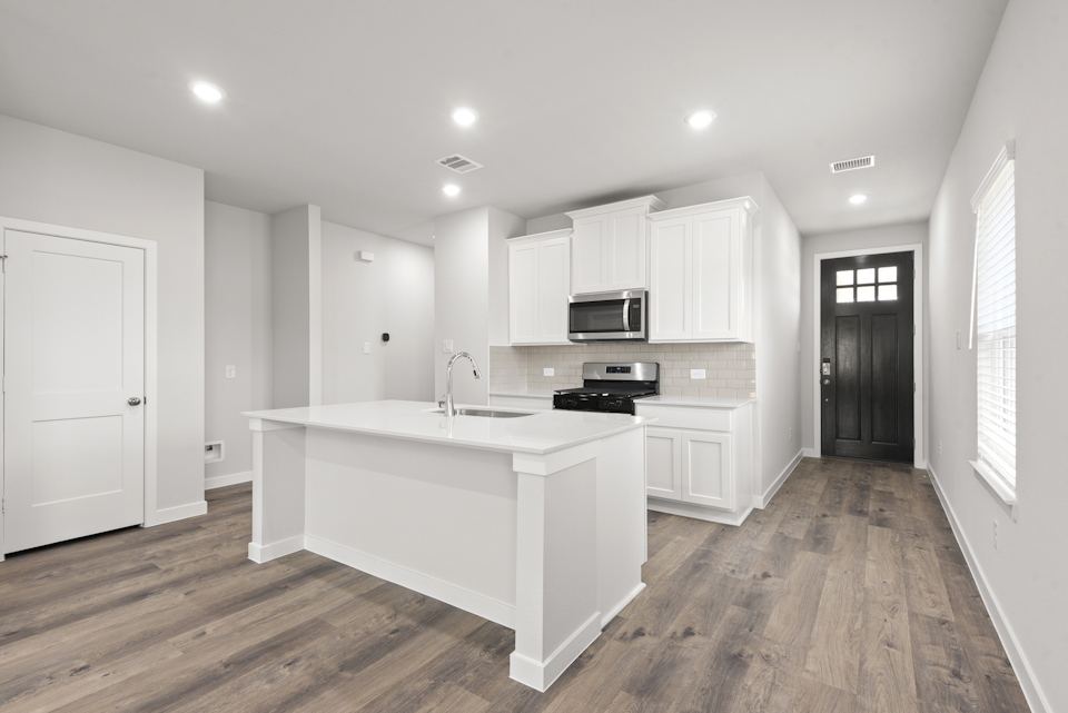 A kitchen with white cabinets.