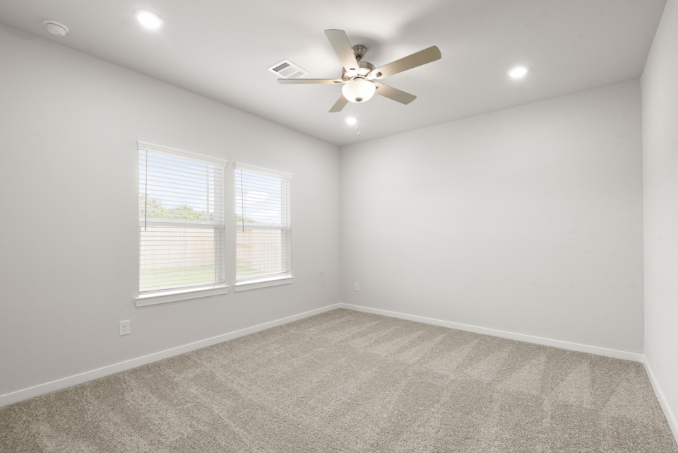 A room with a ceiling fan and a window.