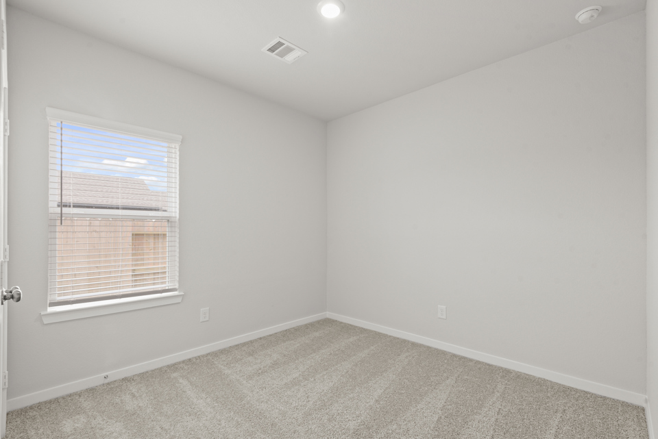 A room with a window and a carpet.